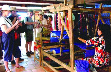 Traditional occupation: International tourists visit a Cham brocade weaving village in Chau Phu District. An Giang Province received 2.4 million visitors in the first six months of this year, an increase of 22 per cent over last year. — VNA/VNS Photo Anh Tuan 08