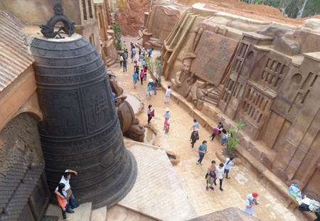 Down history lane: Visitors walk alongside a path through the red bazan soil hill with several sculptures carved on its wall. — Photos coutersy of Trinh Ba Dung tr22a